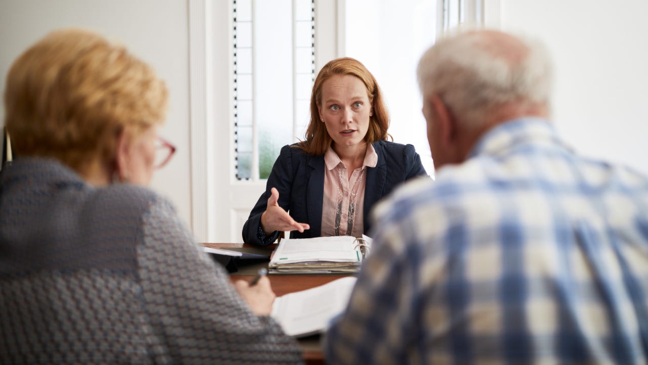 Businesswoman explaining investment plan to retired couple