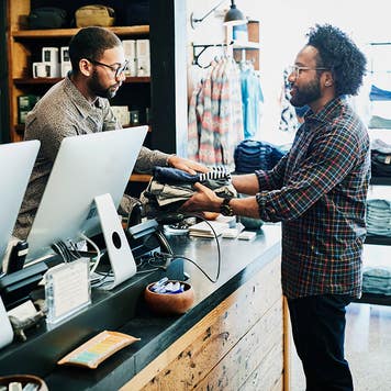 Man handing cloths to cashier