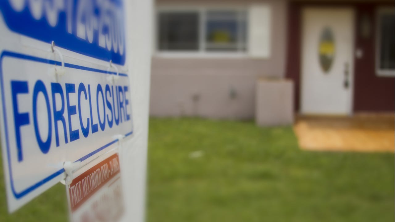 A closeup of a foreclosure sign outside of a home
