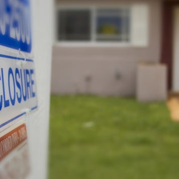 A closeup of a foreclosure sign outside of a home