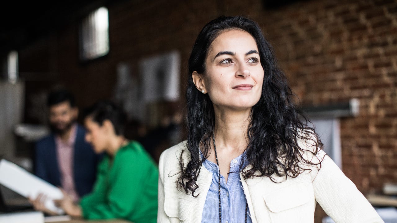 A business woman smiles while in an office