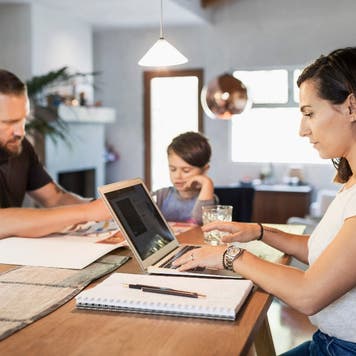 Family sits around a table working