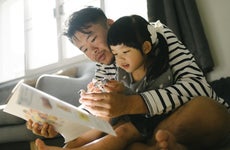 quality times father enjoyment time reading abook with daughter at home weekend activitiy