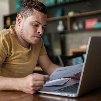 Young man with dwarfism doing home finances