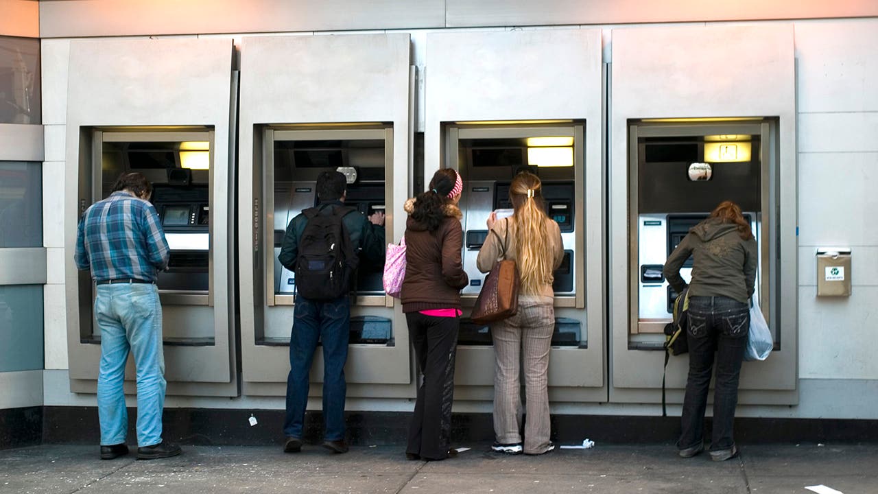 multiple people at a row of atms