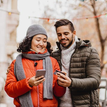 Young couple shopping online outdoors