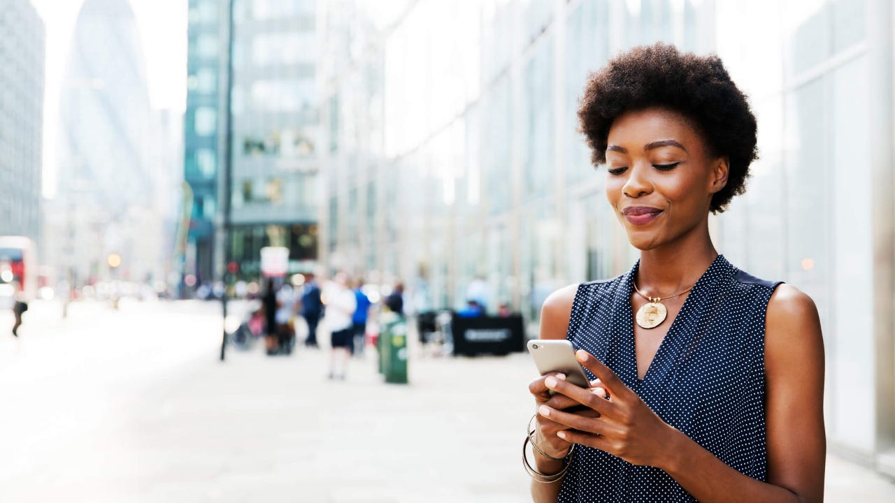 Woman using mobile next to buildings