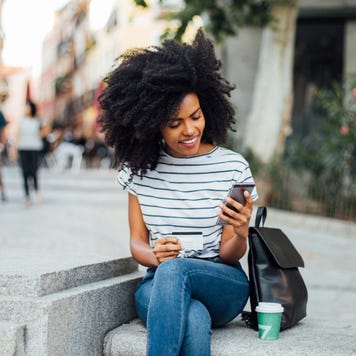 Young woman on phone with credit card