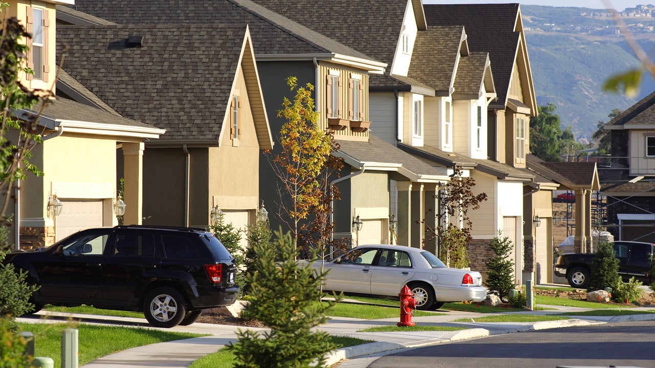 view of suburban homes and cars parked in driveways
