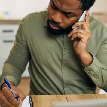 Man takes notes while talking on the phone
