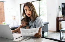 Mother working from home while holding baby