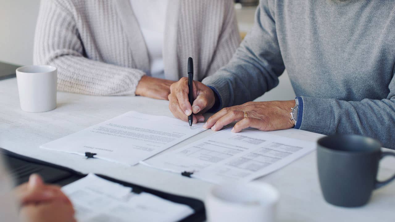 close up of hands of a couple signing paperwork