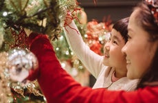 Mom & daughter decorating Christmas Tree