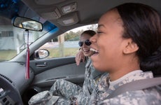 two women in military uniforms driving in a car