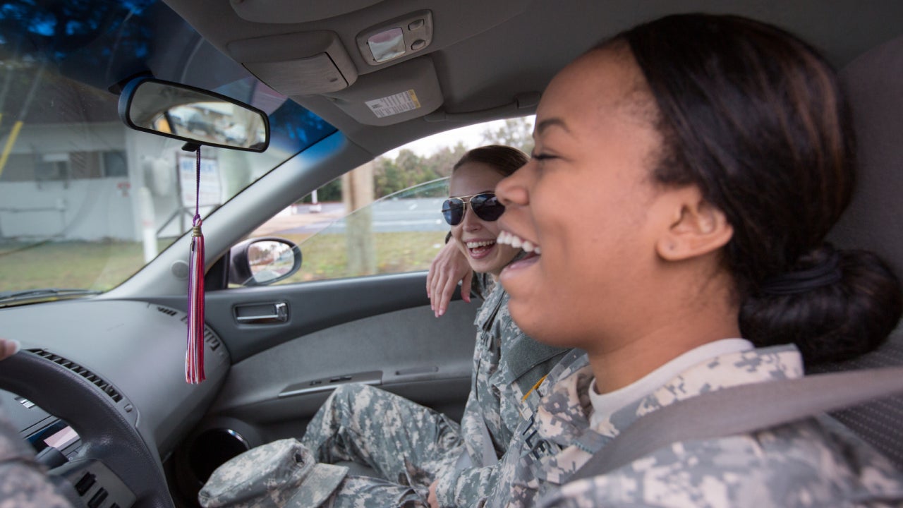 two women in military uniforms driving in a car