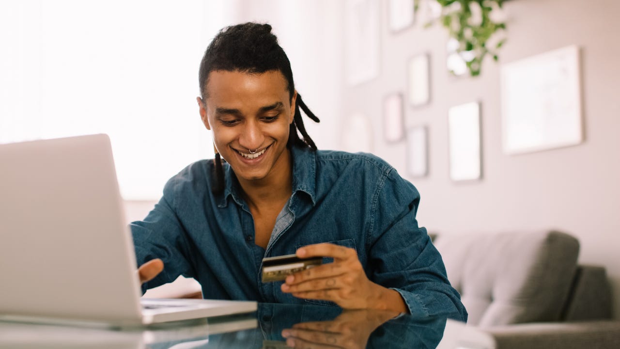 Cheerful young man shopping online