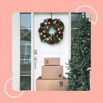 A pile of packages unattended in front of a door with a wreathe on it.