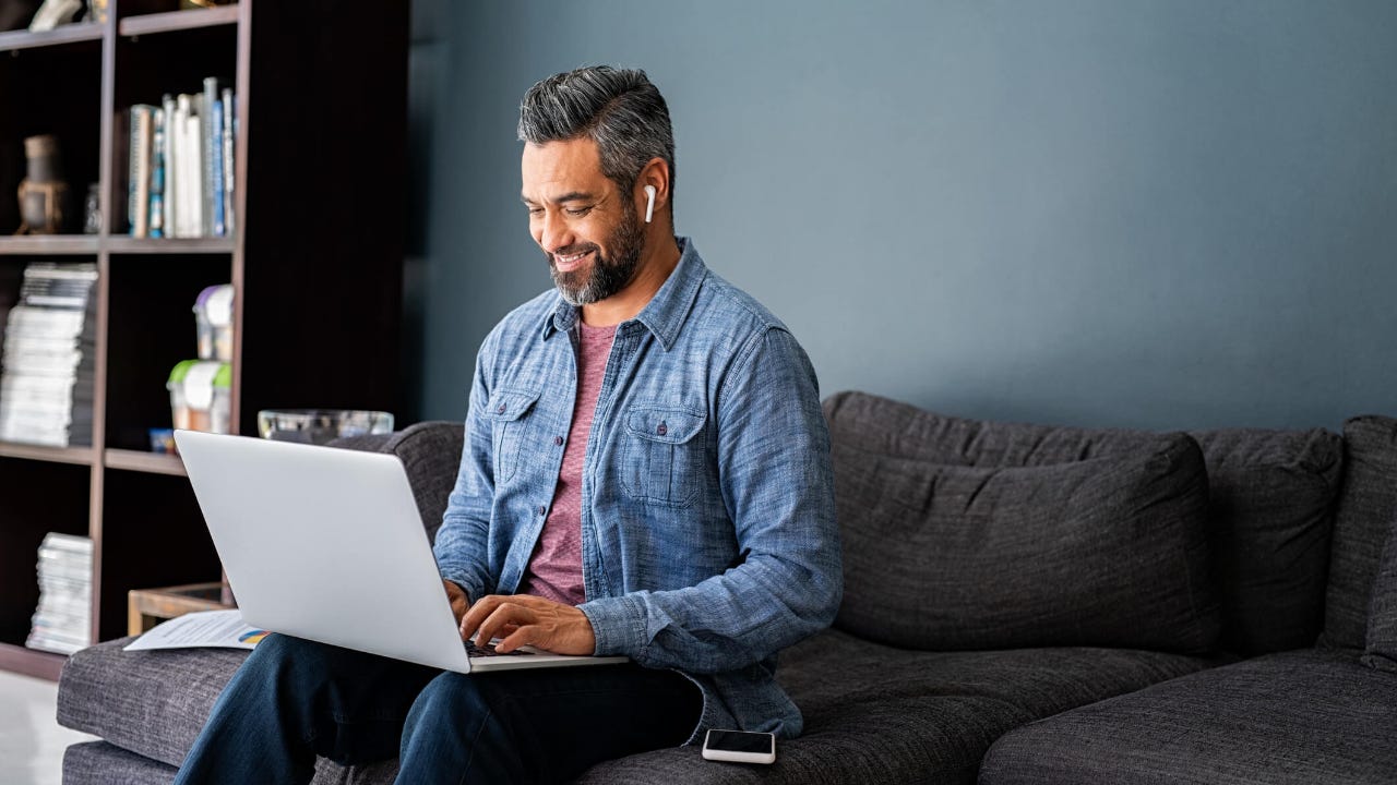 man typing on laptop while working from home