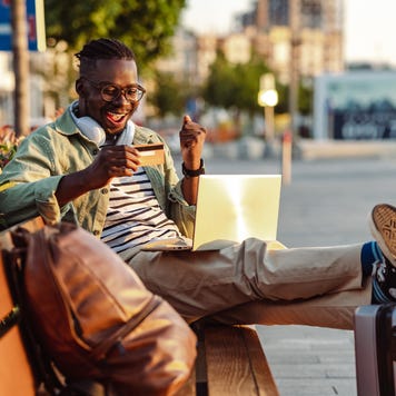 Man sitting on the bench and holding a credit card