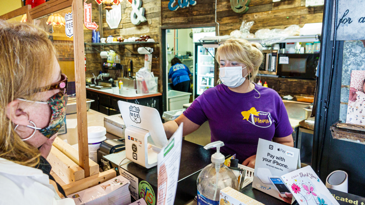Cashier and customer wear face masks at a store during the pandemic