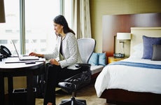 Businesswoman in hotel room working on laptop