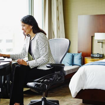 Businesswoman in hotel room working on laptop