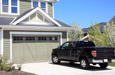 Pretty new two storey home with 4X4 truck parked in driveway.