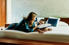 Smiling couple relaxing on bed at luxury hotel