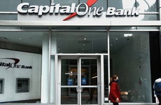 Two people are in front of a Capital One Bank.