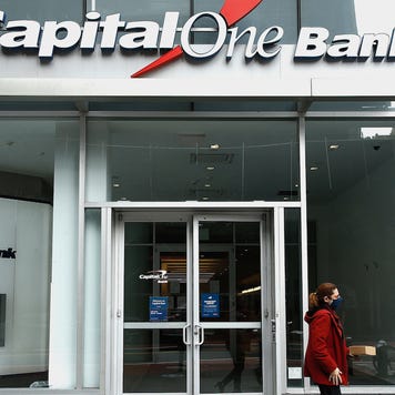 Two people are in front of a Capital One Bank.