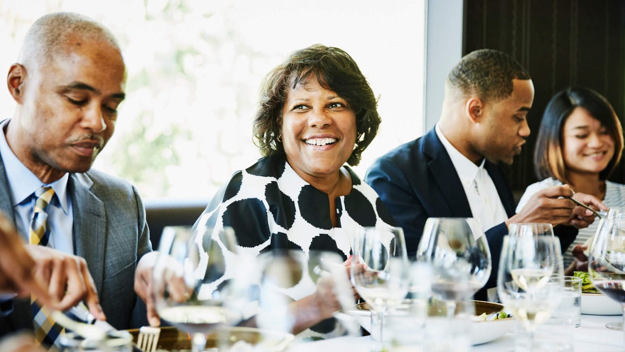 Smiling mature woman sharing a meal with family in restaurant