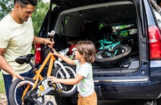 Father and son loading bicycles into car