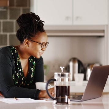 Adult woman using laptop in her kitchen