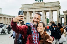 A Mature Couple Take A Selfie Together In Front Of Brandenburg Gate in Berlin