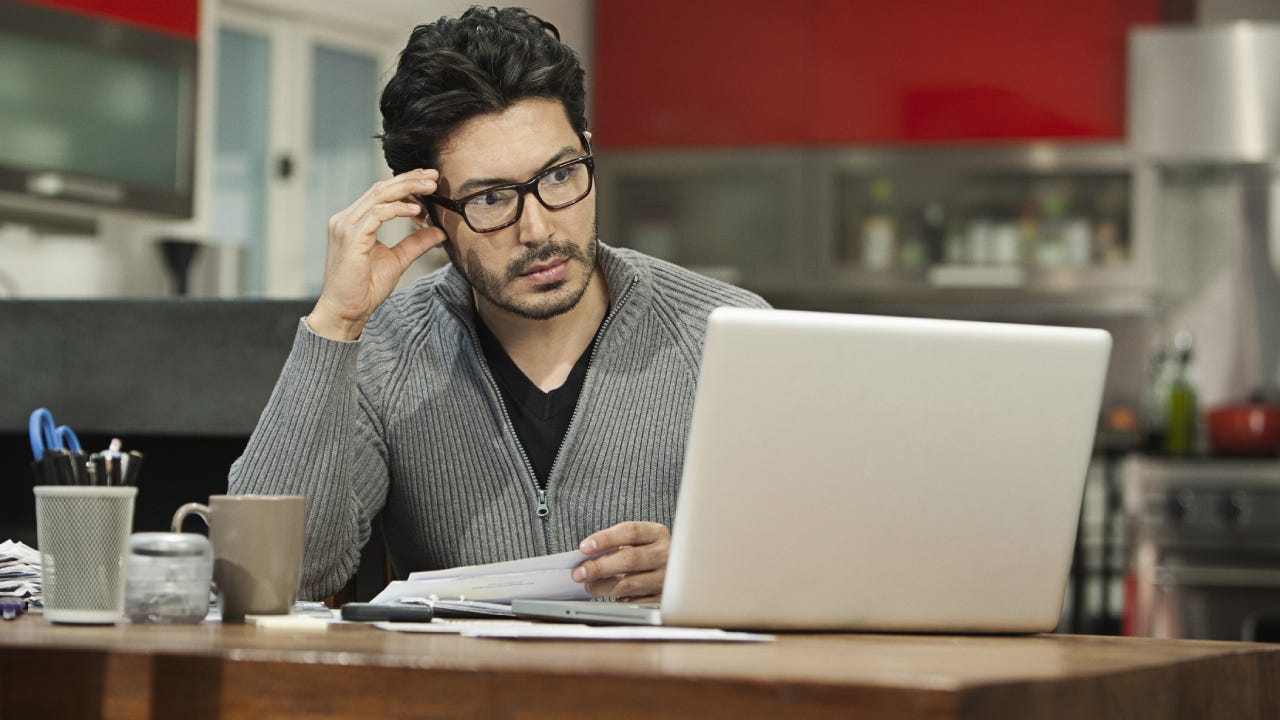 Hispanic man paying bills on computer