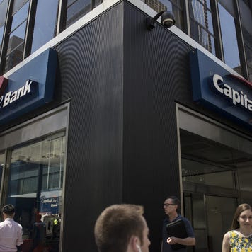 Pedestrians pass in front of a Capital One Financial Corp. bank branch in New York, U.S., on Wednesday, July 19, 2018. Capital One Financial Corp.