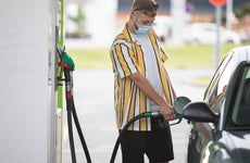 Man getting gas for car wearing mask