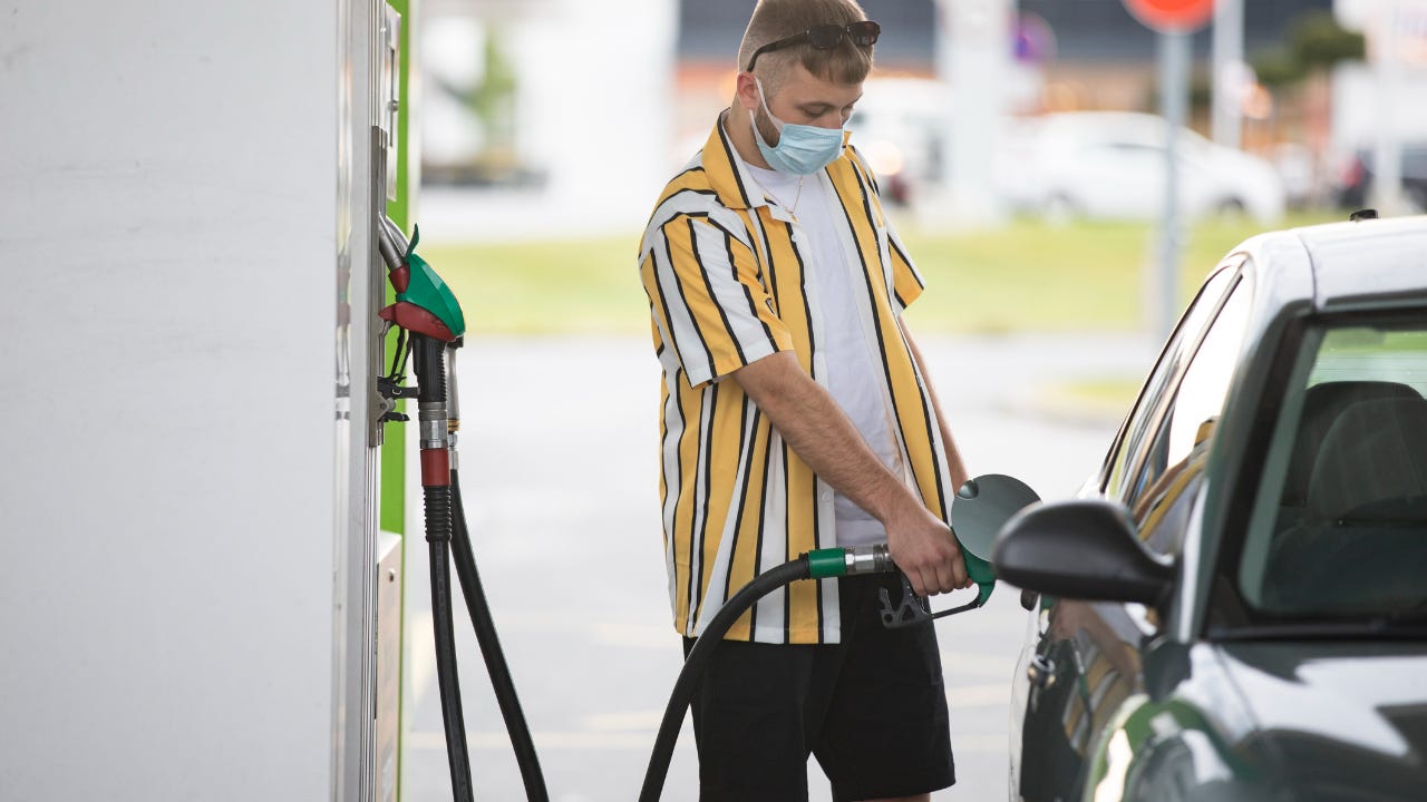 Man getting gas for car wearing mask