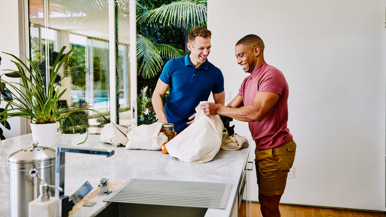 two man setting groceries on kitchen counter