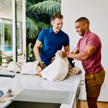 two man setting groceries on kitchen counter