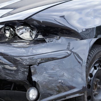 Damaged car with distorted reflection of town