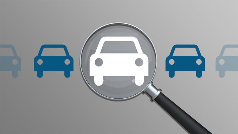 An image of five silhouetted cars, four are blue, the center is white and a magnifying glass is over it.