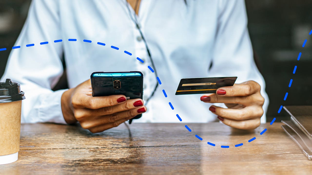 person holding up a phone and card in another hand