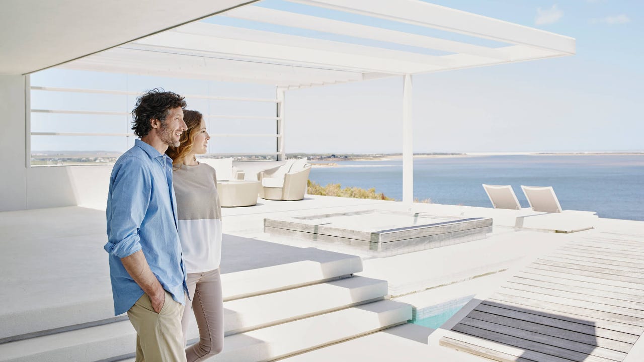 Smiling couple arriving at their breach facing vacation rental