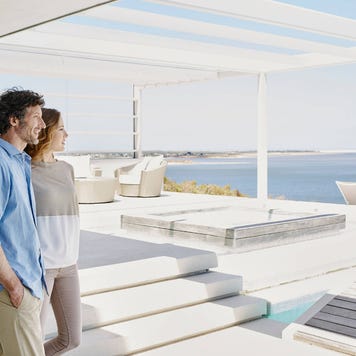 Smiling couple arriving at their breach facing vacation rental