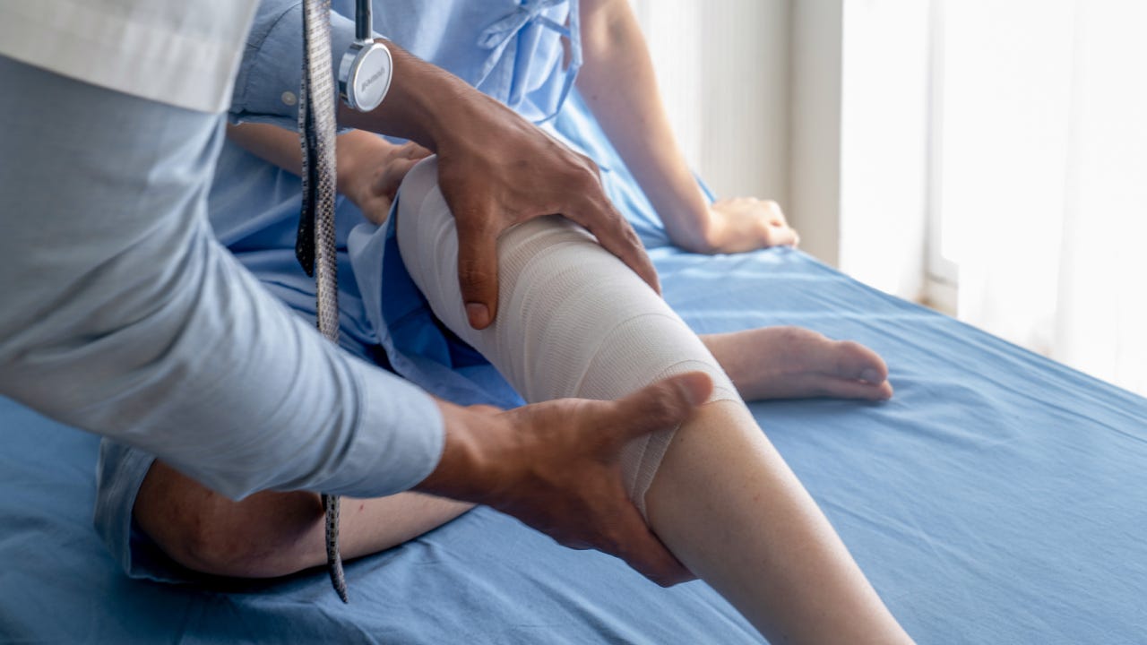 Physical Doctor consulting with patient knee problems physical therapy.