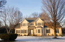 Photo of a colonial American house with light snow on the ground