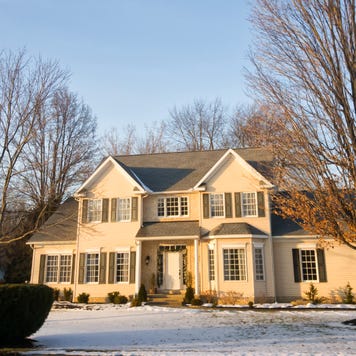 Photo of a colonial American house with light snow on the ground