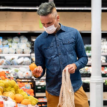 Middle-aged man shopping for oranges at a grocery store