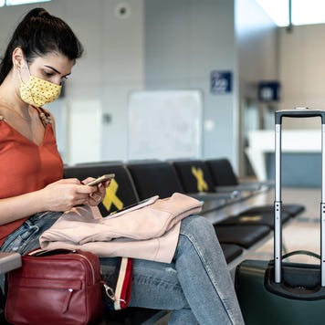 Woman sitting in airport with her luggage
